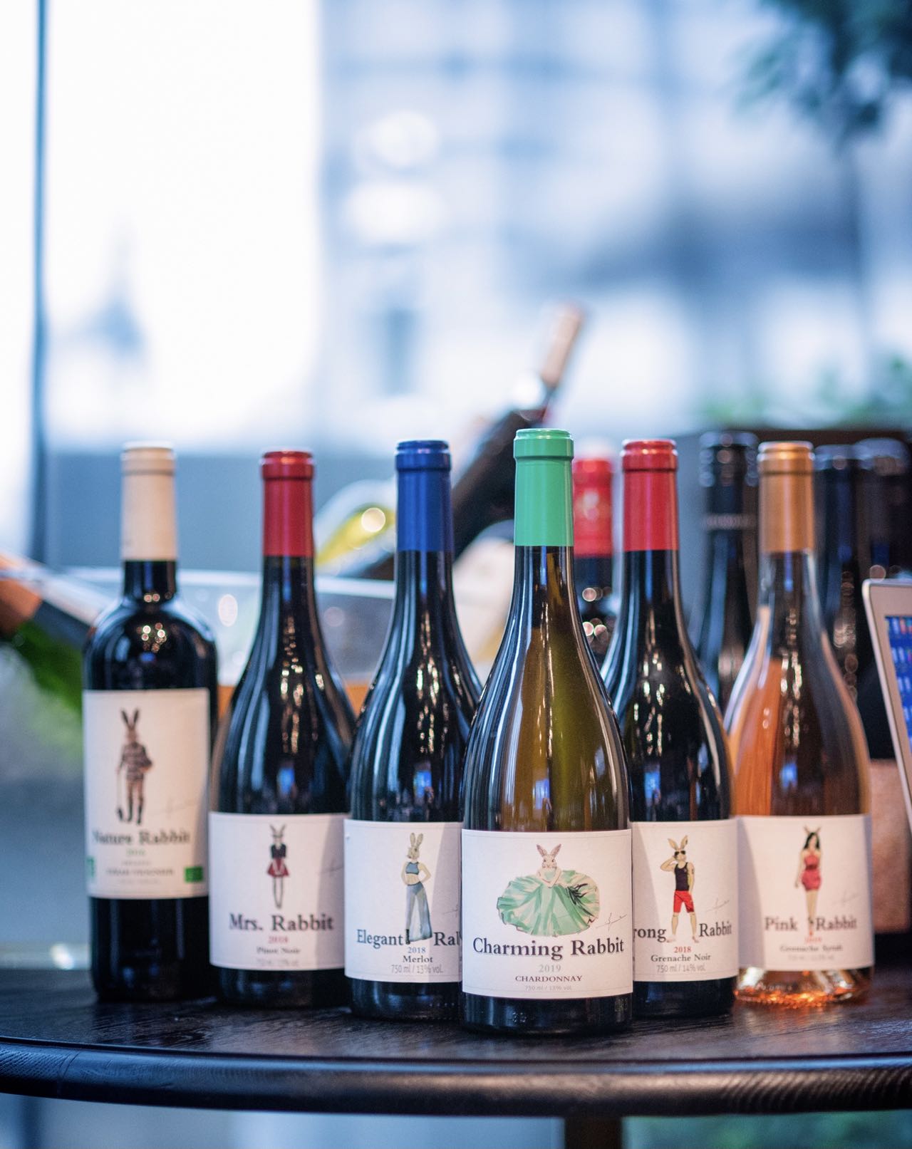 A collection of personalities A group of Rabbit Family wine bottles displayed together on a round table.